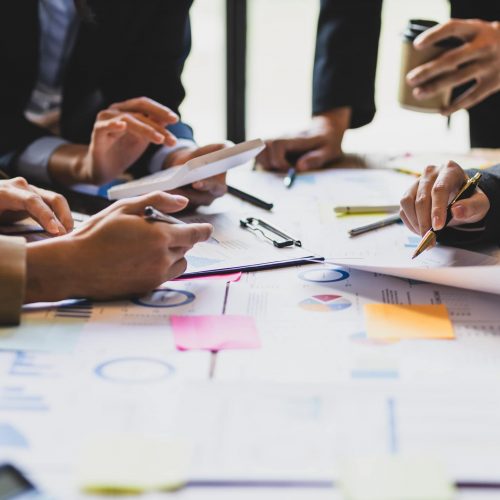 Brainstorm business meeting to discuss analysis of financial figures, graphs and growth charts of business investments to plan new business projects.